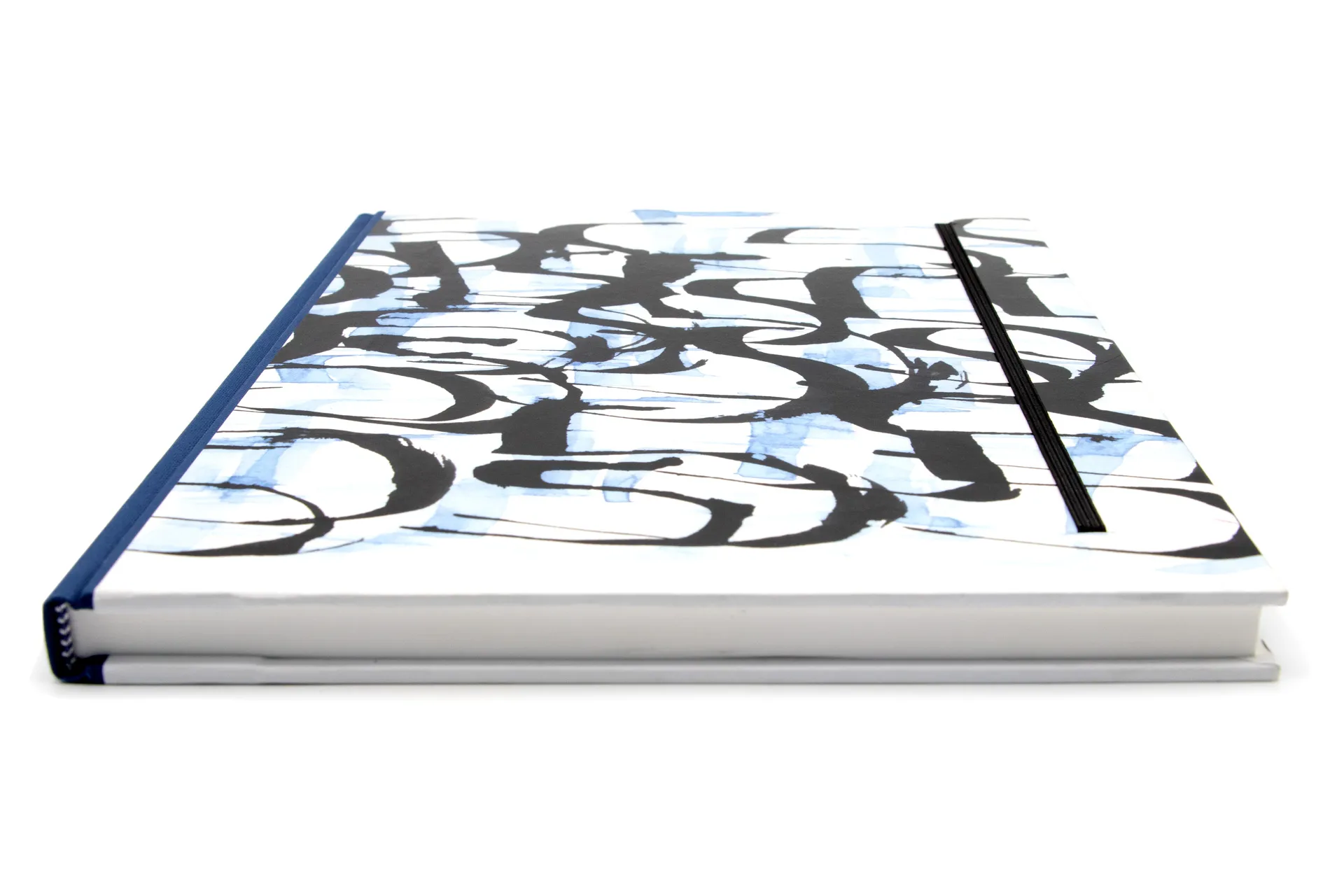 Hardcover-Notizbuch mit kalligrafischem Motiv auf Einband, stabile Fadenheftung und Fixiergummi, in einer großen Ausführung mit blanko Papier