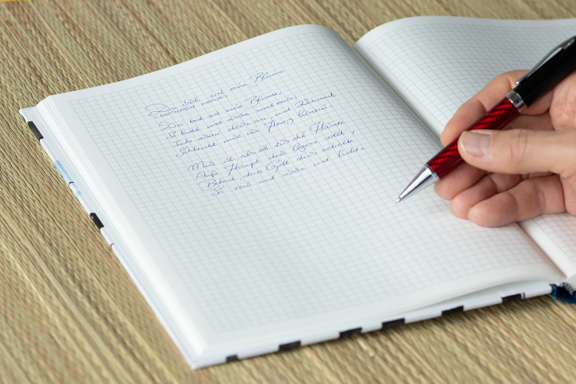 Hardcover-Notizbuch mit kalligrafischem Motiv auf Einband, stabile Fadenheftung und Fixiergummi, in einer großen Ausführung mit kariertem Papier