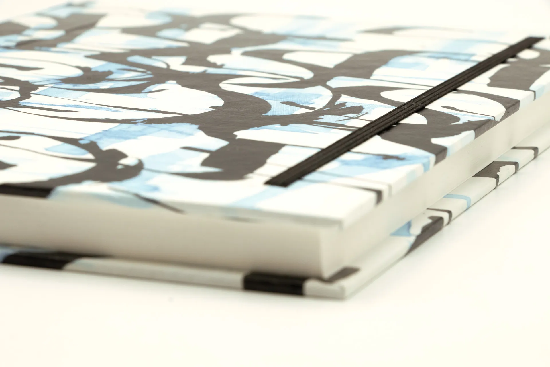 Hardcover-Notizbuch mit kalligrafischem Motiv auf Einband, stabile Fadenheftung und Fixiergummi, in einer mittelgroßen Ausführung mit blanko Papier