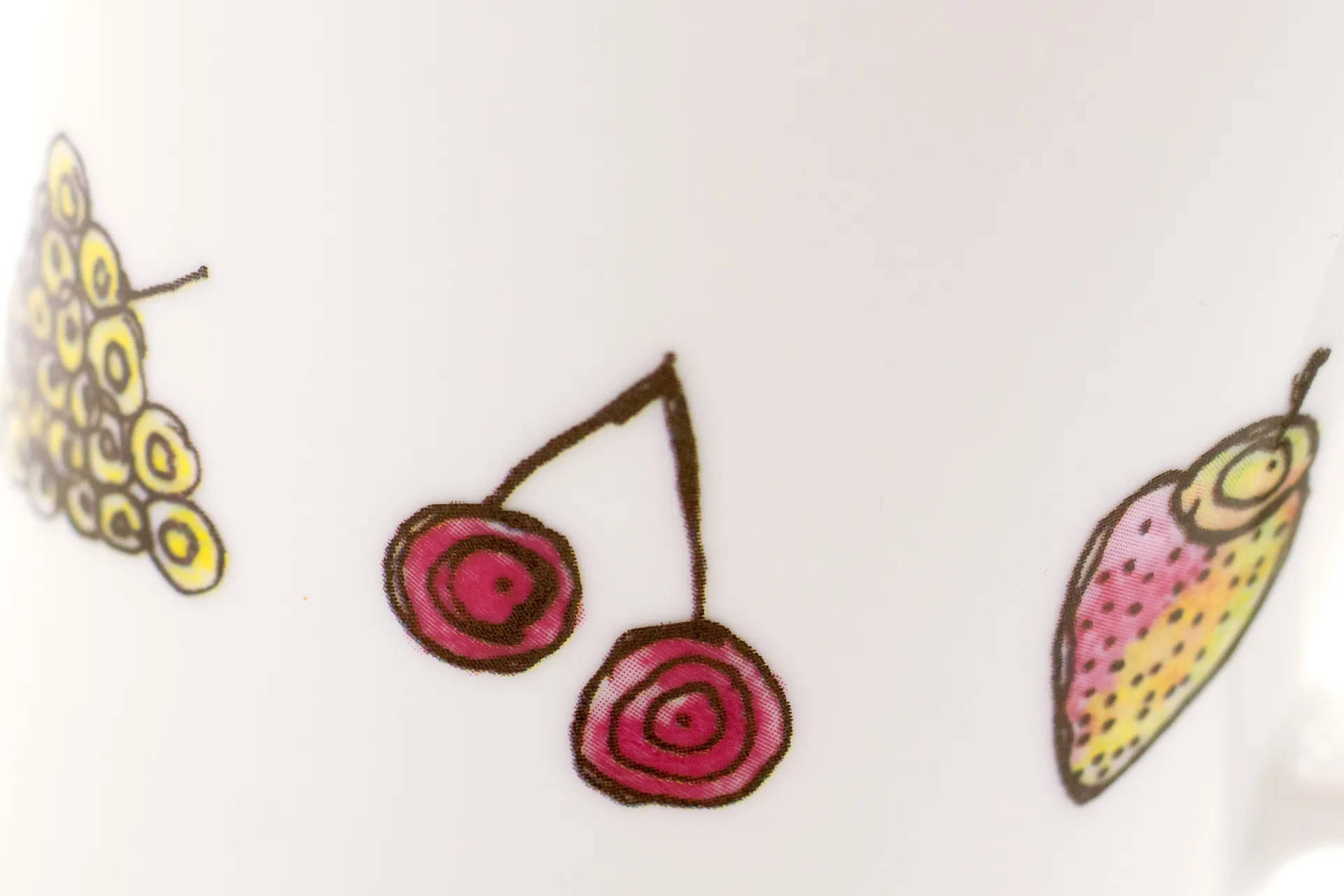 Weiße Porzellantasse mit farbintensivem, handgezeichnetem Früchte-Motiv (z. B. Beeren, Zitrusfrüchte) rundum als Dekor, 0,28 l